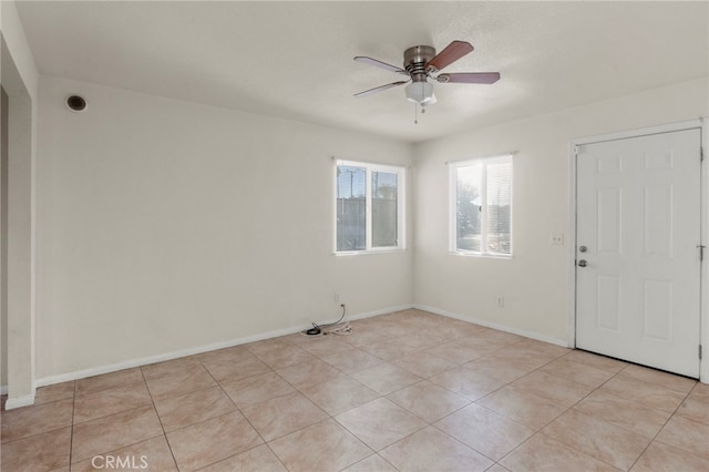 spare room with ceiling fan and light tile patterned floors