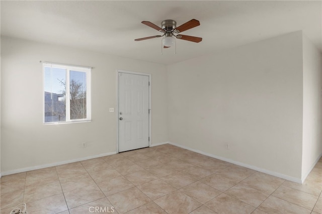 tiled spare room with ceiling fan