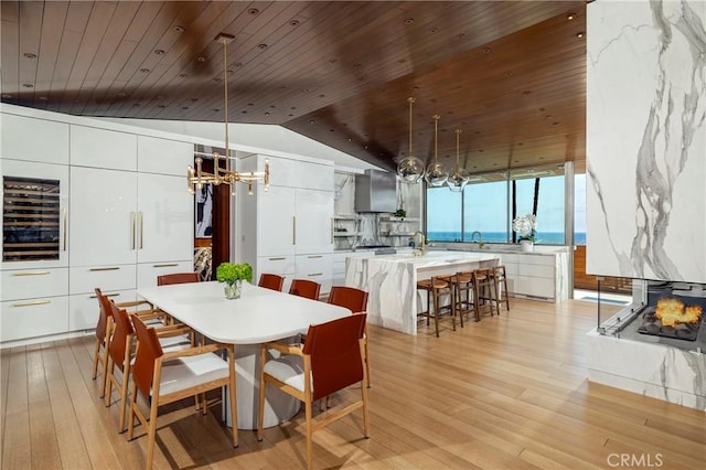 2538 Monaco Dr, Laguna Beach, CA 92651 - dining area featuring a chandelier, wood ceiling, wine cooler, vaulted ceiling, and light wood-style floors
