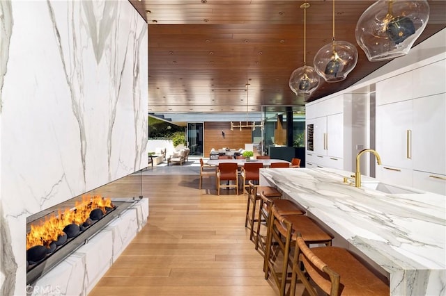 2538 Monaco Dr, Laguna Beach, CA 92651 - dining space with wood ceiling, light wood-style flooring, and a warm lit fireplace