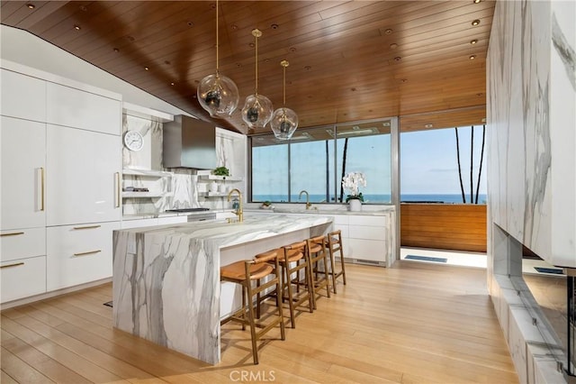 2538 Monaco Dr, Laguna Beach, CA 92651 - kitchen with modern cabinets, wall chimney range hood, white cabinets, wooden ceiling, and light wood-style floors