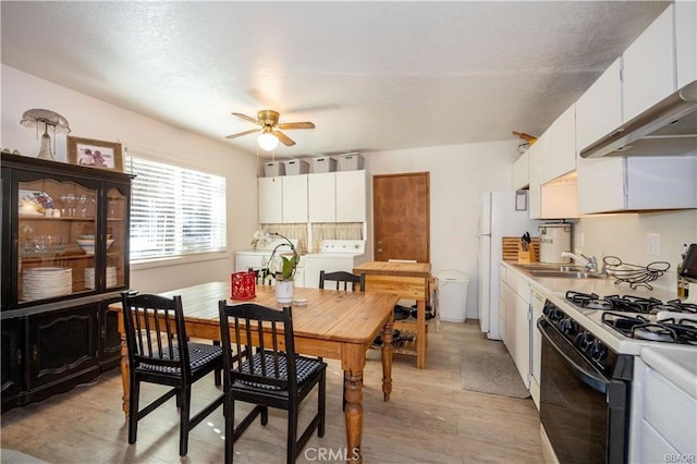 dining space featuring ceiling fan, washer / clothes dryer, sink, and light hardwood / wood-style flooring