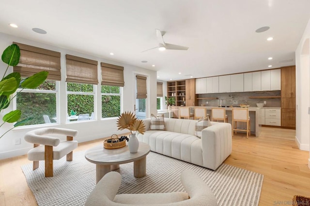 living room with ceiling fan and light hardwood / wood-style floors