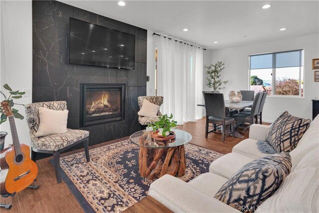 living room with recessed lighting, wood finished floors, and a premium fireplace