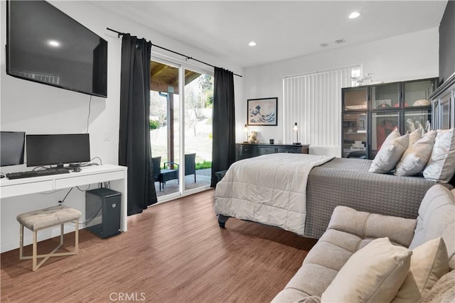 bedroom with access to outside, wood finished floors, and recessed lighting