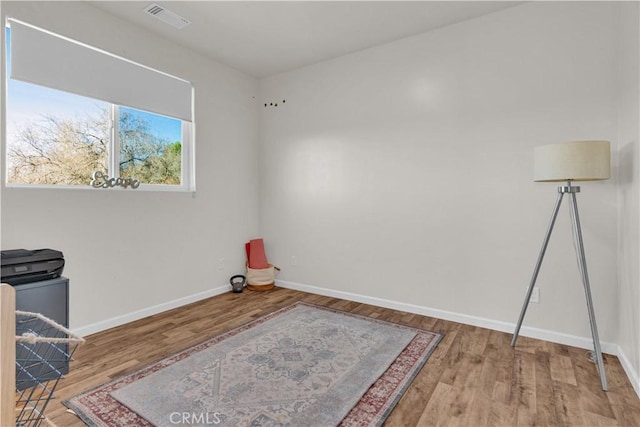 interior space featuring wood finished floors, visible vents, and baseboards