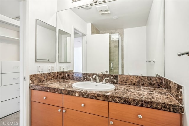 bathroom with vanity and a shower with shower door