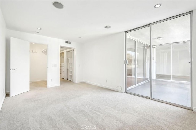 unfurnished bedroom featuring light carpet, access to exterior, and a closet