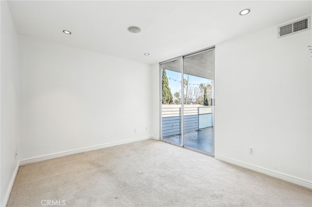 carpeted spare room featuring floor to ceiling windows