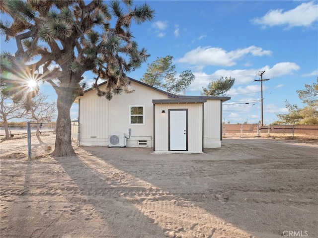 back of property featuring ac unit and a storage shed