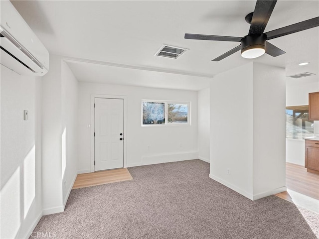 carpeted empty room with an AC wall unit and ceiling fan