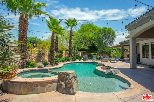 view of pool with a patio area and an in ground hot tub