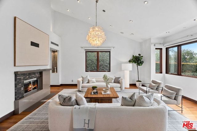 living room with lofted ceiling, hardwood / wood-style floors, and a notable chandelier