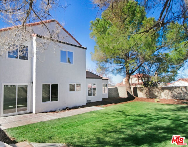 rear view of property featuring a lawn