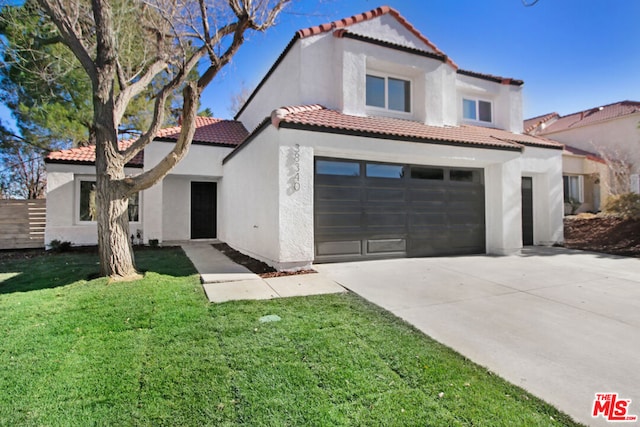 mediterranean / spanish house featuring a garage and a front yard