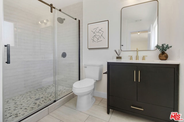 bathroom featuring vanity, a shower with shower door, tile patterned floors, and toilet