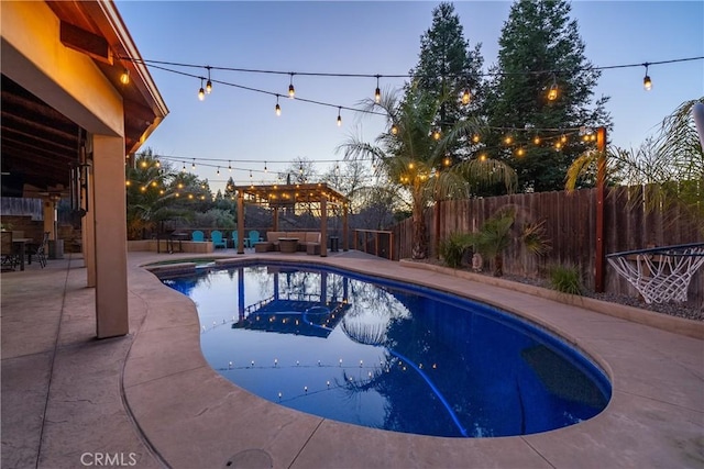 pool at dusk featuring a patio area and a pergola