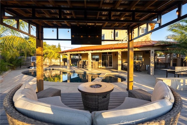 view of patio featuring a fire pit, a fenced in pool, and exterior bar