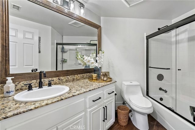 full bathroom featuring bath / shower combo with glass door, toilet, and vanity