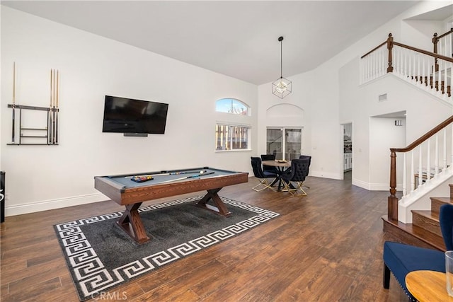 game room with a towering ceiling, dark wood-type flooring, and pool table