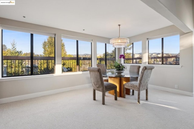 dining room with carpet and an inviting chandelier