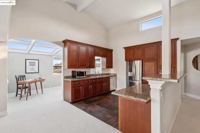 kitchen with light stone countertops, dark carpet, appliances with stainless steel finishes, and a kitchen island