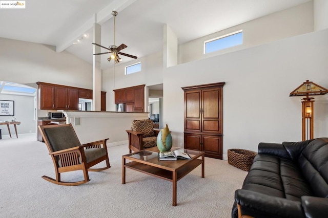 living room featuring light colored carpet, ceiling fan, beam ceiling, and a high ceiling