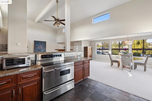 kitchen with ceiling fan, double oven range, beamed ceiling, high vaulted ceiling, and dark colored carpet