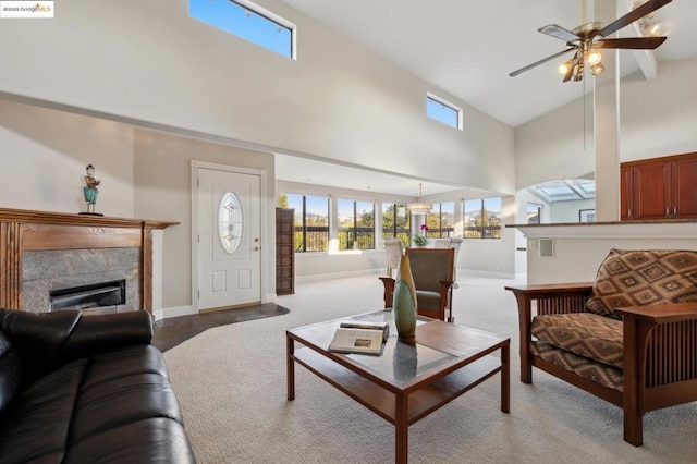 carpeted living room featuring ceiling fan, a fireplace, and high vaulted ceiling