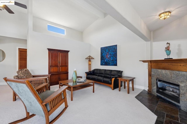 living room with ceiling fan, a towering ceiling, and a fireplace