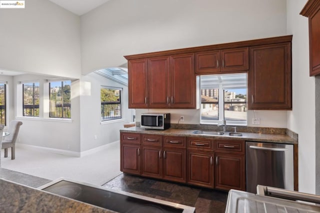 kitchen featuring appliances with stainless steel finishes, sink, and dark colored carpet