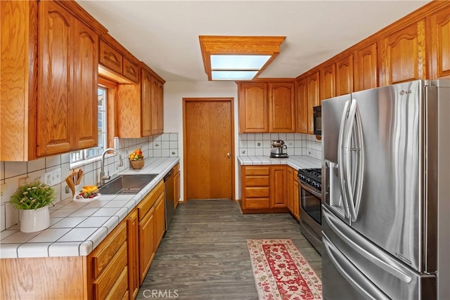 kitchen featuring tile counters, sink, backsplash, and stainless steel appliances