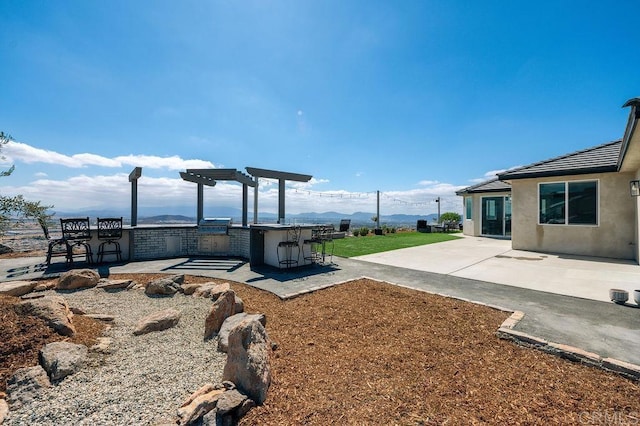 view of yard with an outdoor bar, a pergola, a mountain view, and a patio