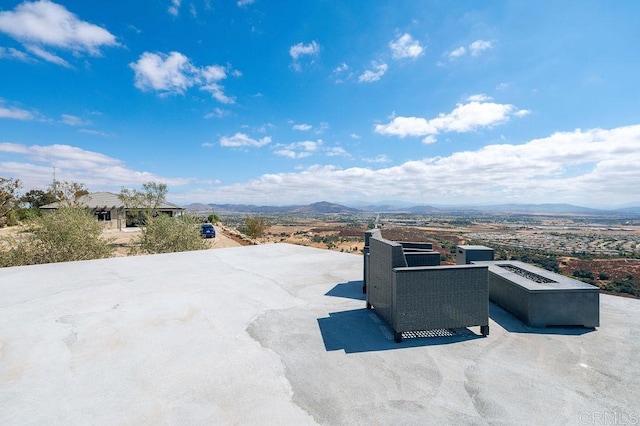 view of patio / terrace with a mountain view and a fire pit