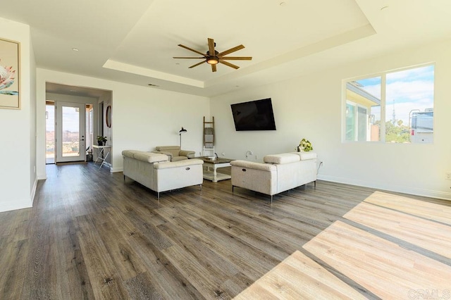 living room featuring ceiling fan, dark hardwood / wood-style flooring, french doors, and a tray ceiling