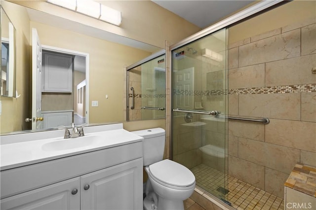 bathroom with an enclosed shower, vanity, and toilet