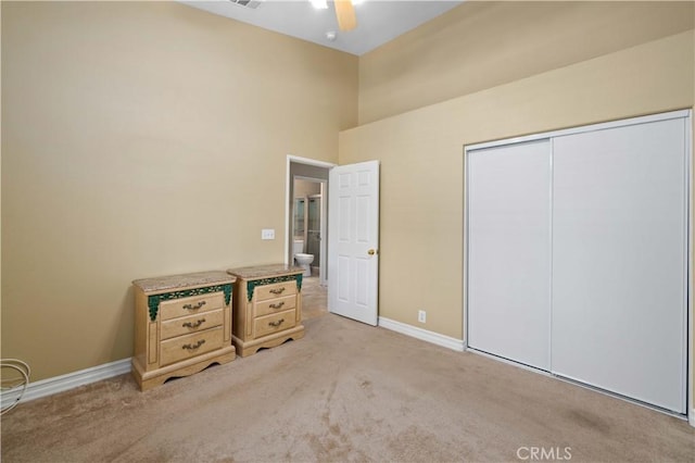 unfurnished bedroom featuring ceiling fan, a closet, and light carpet