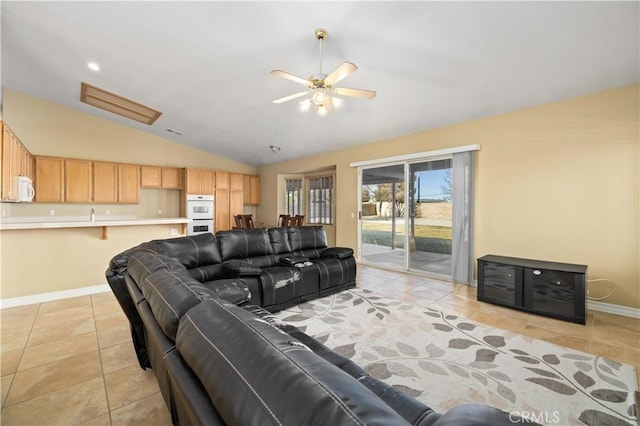 living room featuring ceiling fan, light tile patterned flooring, and vaulted ceiling