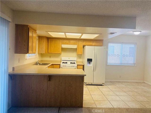 44504 Watford Ave, Lancaster, CA 93535 - kitchen featuring white appliances, under cabinet range hood, light countertops, a peninsula, and light tile patterned floors