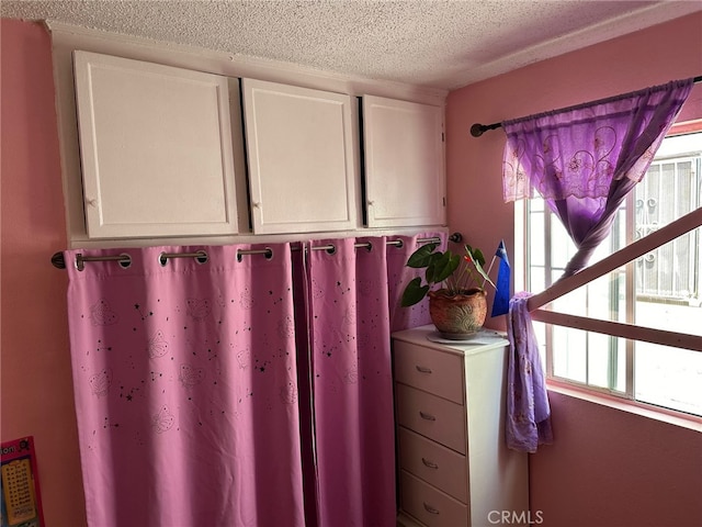 miscellaneous room with a textured ceiling