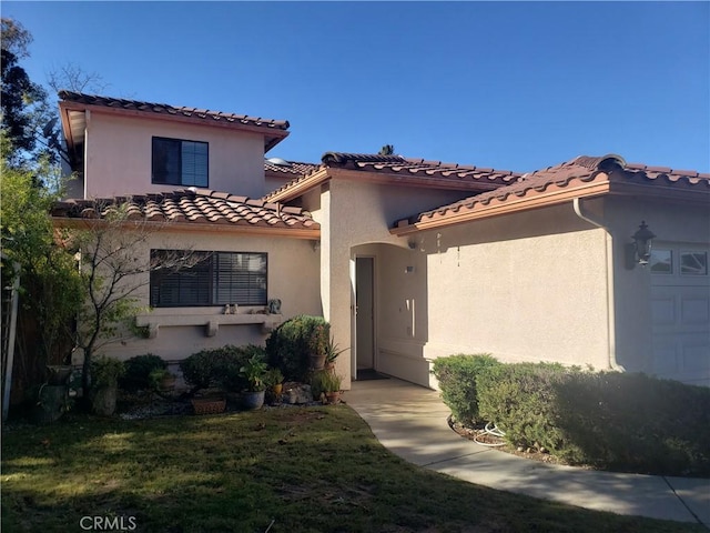 mediterranean / spanish home with a garage and a front yard