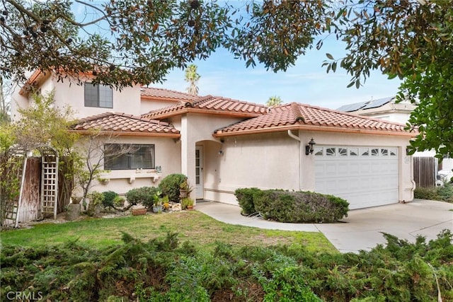 mediterranean / spanish house with an attached garage, a tile roof, driveway, stucco siding, and a front yard