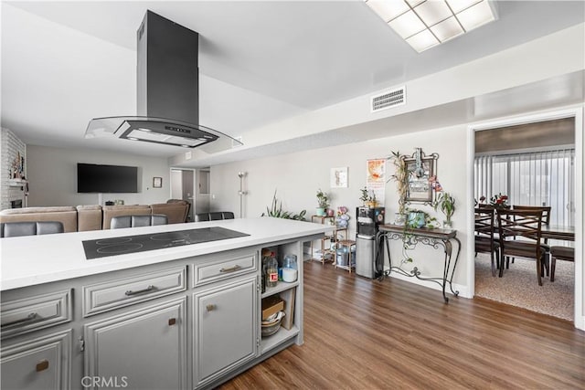 44028 Halcom Ave, Lancaster, CA 93536 - kitchen featuring dark hardwood / wood-style floors, island exhaust hood, gray cabinets, and black electric cooktop