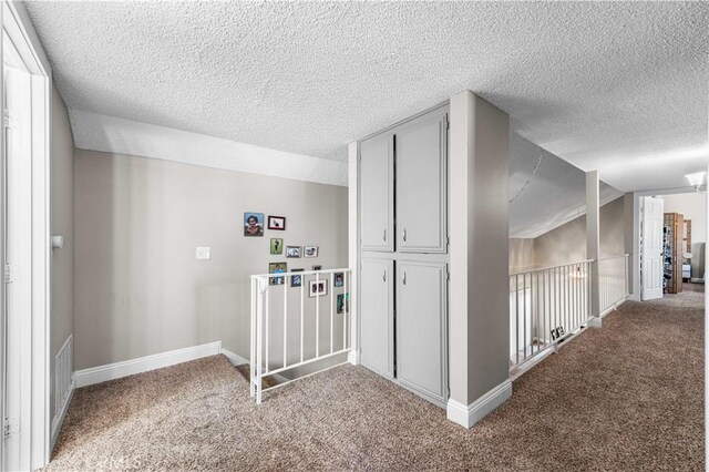 44028 Halcom Ave, Lancaster, CA 93536 - corridor with carpet floors, a textured ceiling, and lofted ceiling