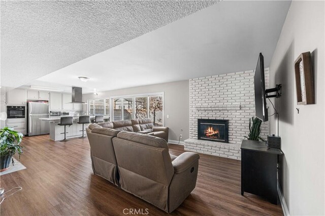 44028 Halcom Ave, Lancaster, CA 93536 - living room featuring a brick fireplace, hardwood / wood-style floors, and a textured ceiling