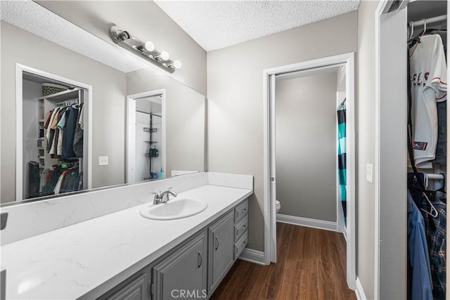 44028 Halcom Ave, Lancaster, CA 93536 - bathroom with a textured ceiling, vanity, toilet, a shower with shower curtain, and hardwood / wood-style flooring
