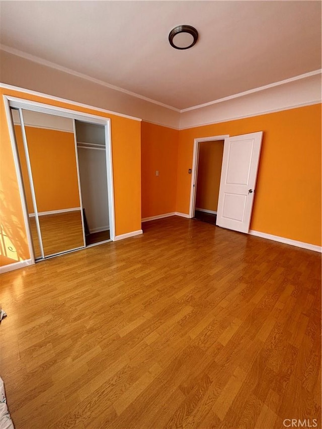 unfurnished bedroom featuring a closet and hardwood / wood-style flooring