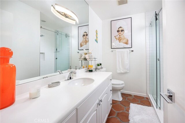 bathroom featuring toilet, tile patterned floors, an enclosed shower, and vanity