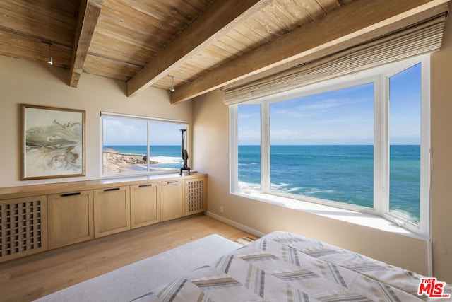 bedroom with beam ceiling, light hardwood / wood-style flooring, a water view, a beach view, and wooden ceiling