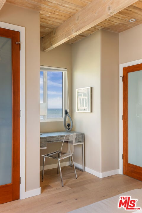 interior space with beam ceiling, light wood-type flooring, wood ceiling, and french doors